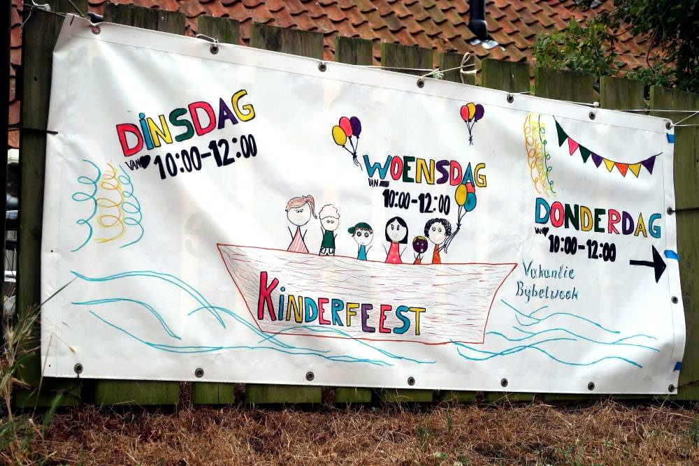 Zelfgemaakt spandoek met de dagen en tijden van het kinderfeest